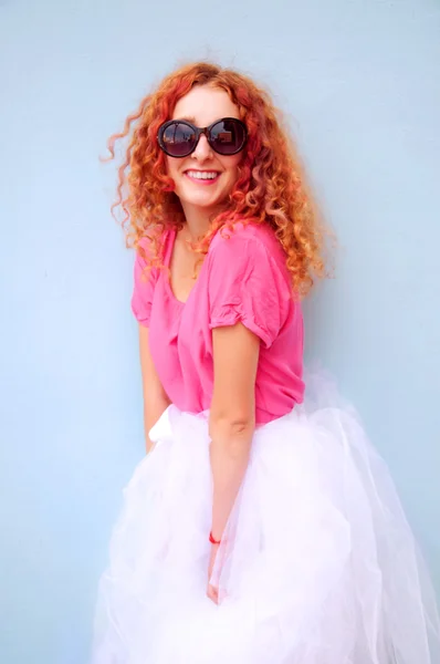 Jeune femme souriante aux cheveux roux bouclés portant des lunettes — Photo