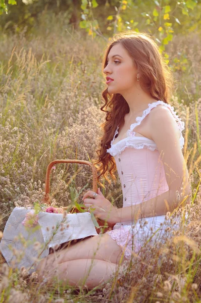 Młoda kobieta zbierania ziół w polu — Zdjęcie stockowe