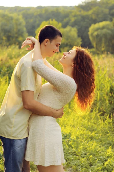 Paar van jonge geliefden knuffelen in het veld — Stockfoto