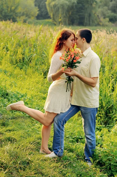 Paar van jonge geliefden knuffelen in het veld — Stockfoto