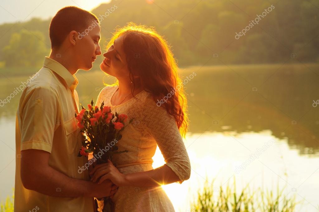 Couple of young lovers hugging in the sunset light