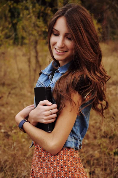 本を読んで秋の森のかわいい若い女性 — ストック写真