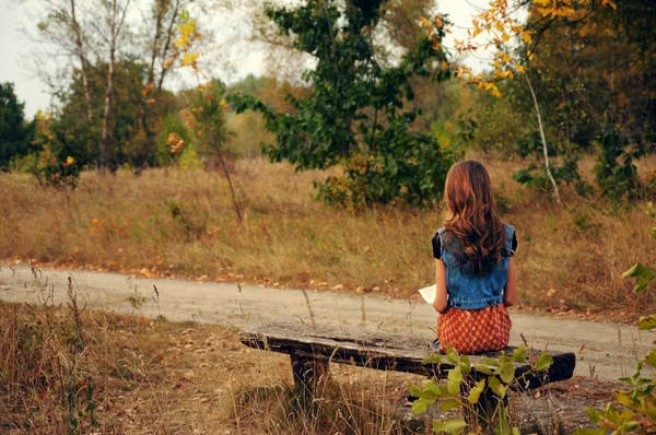 Gadis menunggu bus di pedesaan. — Stok Foto