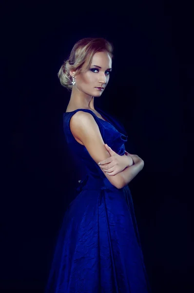 Studio portrait of beautiful blonde woman in dark blue dress — Stock Photo, Image