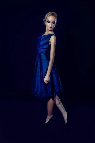 Studio portrait of beautiful blonde woman in dark blue dress — Stock Photo, Image