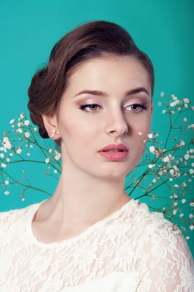 Mooie vrouw in witte jurk op turkooizen achtergrond — Stockfoto