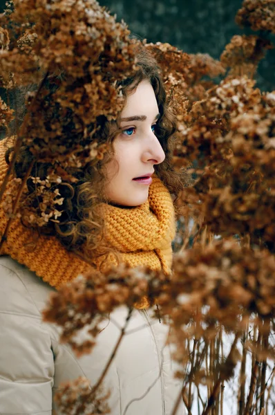 Jovem mulher atraente com cabelo encaracolado perto de fluxo de hortênsia seca — Fotografia de Stock