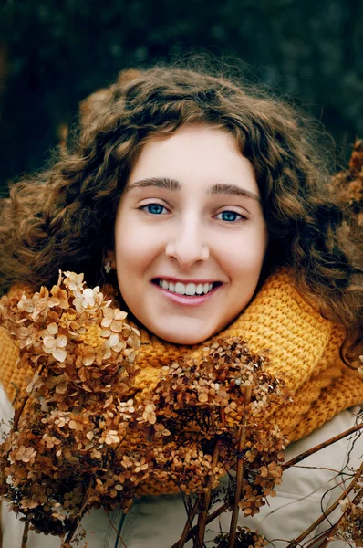 Ελκυστική νεαρή γυναίκα με σγουρά μαλλιά κοντά ροή αποξηραμένα Ορτανσία — Φωτογραφία Αρχείου