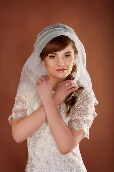 Beautiful young bride with retro hairstyle wearing white veil — Stock Photo, Image