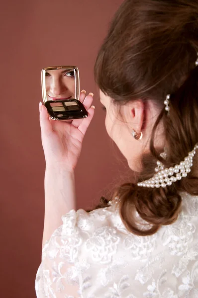 Young woman looking into a small mirror — Stock Photo, Image
