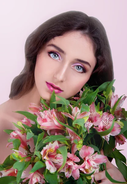 Mujer joven con ojos grises y cabello largo y castaño que sostiene el flujo rosa —  Fotos de Stock