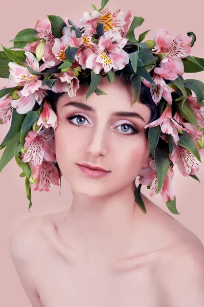 Pembe çiçekler kafasına giyen genç kadın — Stok fotoğraf