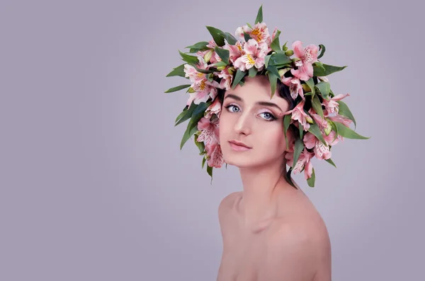 Jovem mulher usando flores cor de rosa na cabeça — Fotografia de Stock