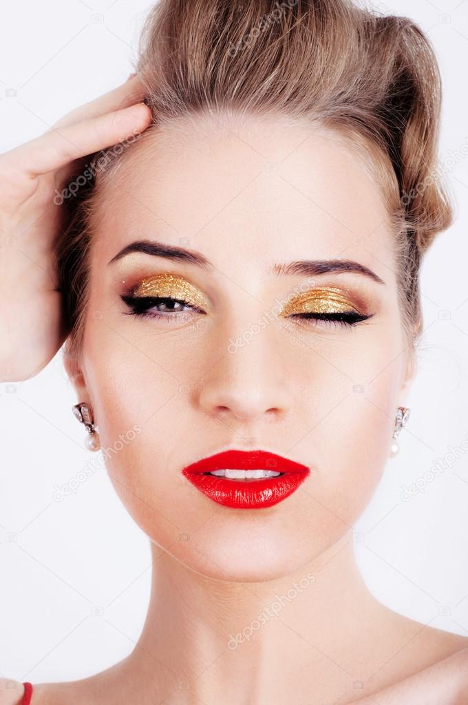 Beautiful sexy woman with party makeup winking
