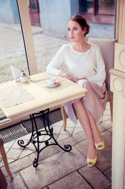 Çay içme bir kafede oturan güzel zarif sarışın