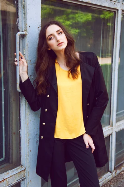 Retrato de mujer joven en gabardina negra y blusa amarilla —  Fotos de Stock