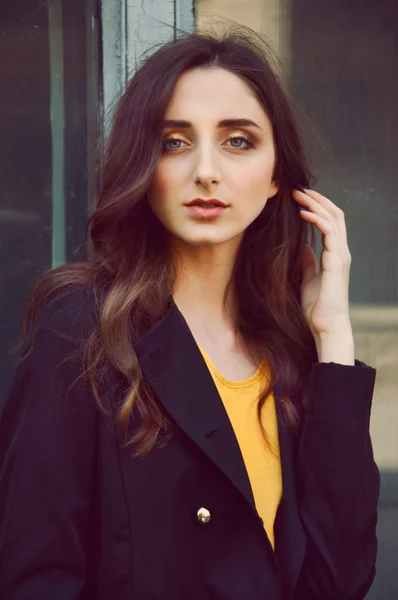Retrato de mujer joven en gabardina negra y blusa amarilla —  Fotos de Stock