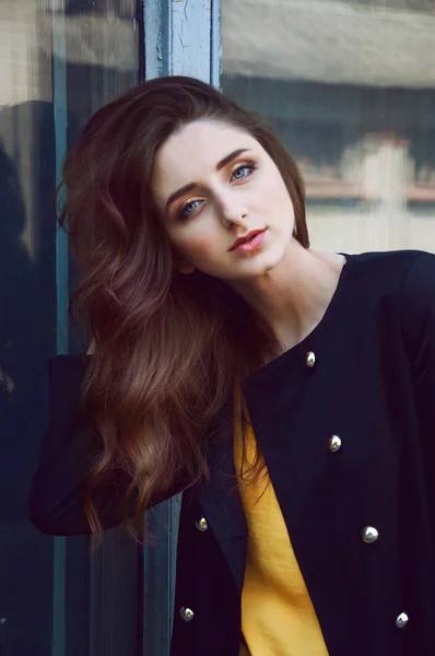 Портрет молодой женщины в чёрном пальто и жёлтой блузке — стоковое фото