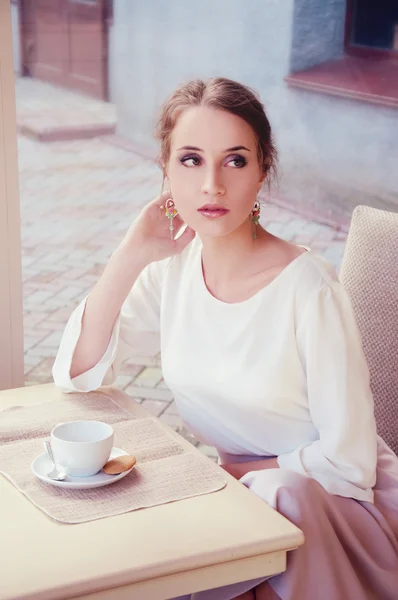 Hermosa rubia elegante sentada en un café bebiendo té — Foto de Stock