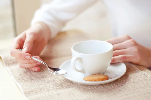 Una donna che beve tè in un caffè. Mani in primo piano . — Foto Stock