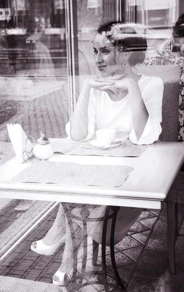 Hermosa rubia elegante sentada en un café bebiendo té. Imagen de archivo