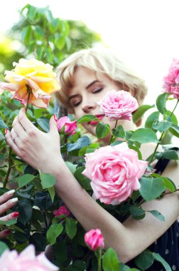 Bahçede poz mavi elbiseli güzel sarışın kadın