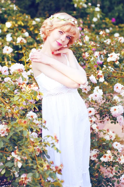 Όμορφη ξανθιά γυναίκα που παρουσιάζουν στο rose garden — Φωτογραφία Αρχείου