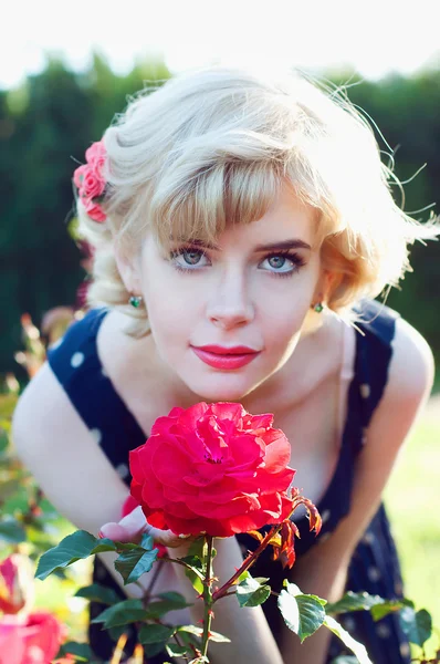 Beautiful blonde woman posing in the rose garden — Stock Photo, Image