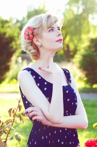 Hermosa mujer rubia en vestido azul posando en el jardín — Foto de Stock