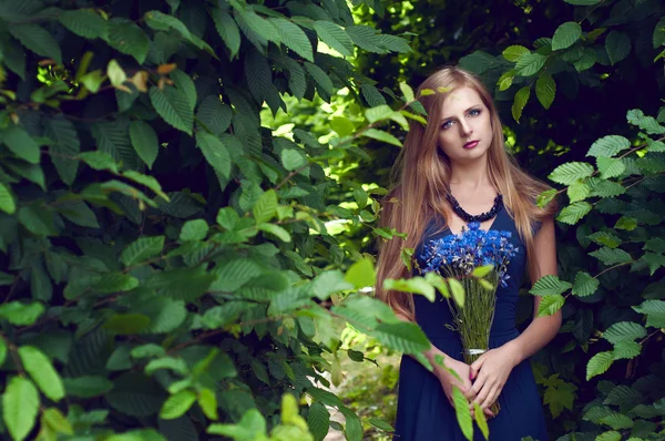 Blonde caucasian woman holding a cornflower bouquet — Stock Photo, Image