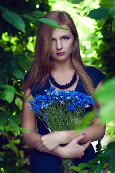 Blonde Kaukasierin mit einem Kornblumenstrauß — Stockfoto