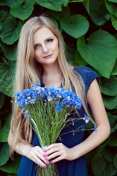 Blonde caucasian woman holding a cornflower bouquet — Stock Photo, Image