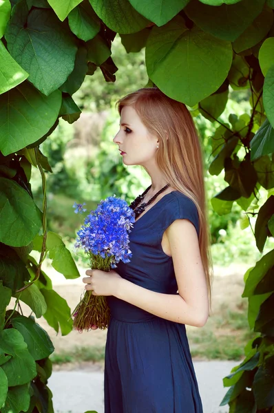 Blonde caucasian woman holding a cornflower bouquet — Stock Photo, Image