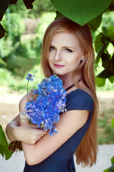 Blonde caucasian woman holding a cornflower bouquet — Stock Photo, Image