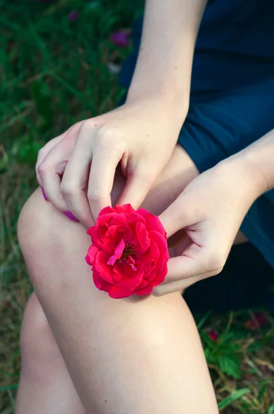 Frau mit roter Rose auf dem Schoß — Stockfoto