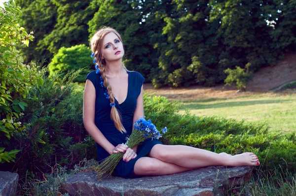 Blonde caucasian woman with cornflowers in her braid — Stock Photo, Image