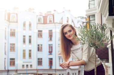 Gülümsediğini balkon üzerinde sarışın genç kadın