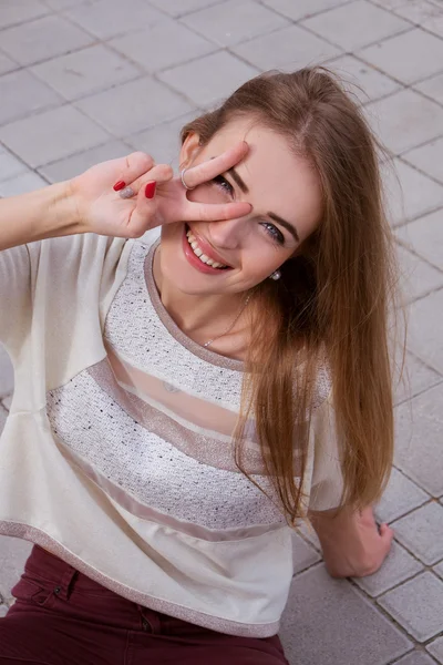 Menina adolescente feliz sorrindo e mostrando sinal de vitória — Fotografia de Stock