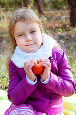 Sevimli küçük sarışın çocuk bir elma tutan
