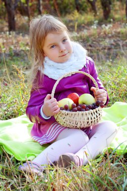 Sevimli küçük sarışın çocuk meyve sepeti tutan 