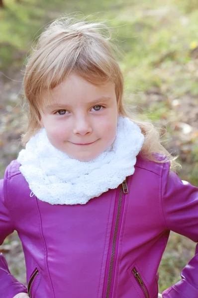 Schattig klein blond meisje in een witte sjaal ziet eruit als een waaghals — Stockfoto