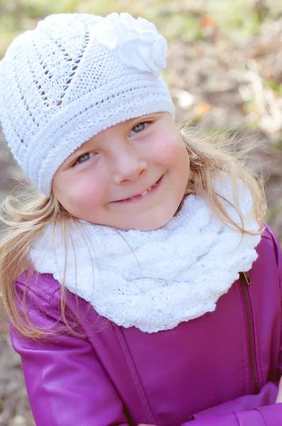 Schattig klein blond meisje in een witte gebreide muts en sjaal. La Val — Stockfoto