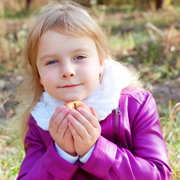 Sevimli küçük sarışın çocuk bir elma tutan — Stok fotoğraf