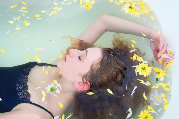 Jovem com cabelo encaracolado tomando um banho com ervas — Fotografia de Stock