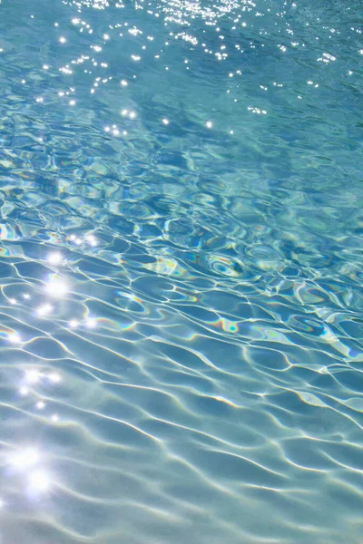 太陽の光で輝く澄んだ青い水の波紋に近い背景材料のための写真 — ストック写真