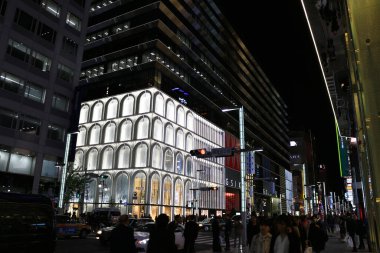 13 Nisan 2018 Ginza, Tokyo, Japonya birçok insanın ve arabanın Japonya 'nın en ünlü alışveriş caddesi Ginza' nın ana caddesine gelip geçtiği canlı gece manzarası