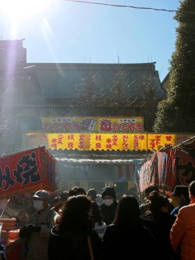 3 Ocak 2015, Kawasaki Şehri, Kanagawa Bölgesi, Japonya Yeni Yıl ziyaretçileri Kawasaki Daishi Tapınağı 'nda sıralanmış yiyecek ve içeceklerin tadını çıkarıyorlar.. 