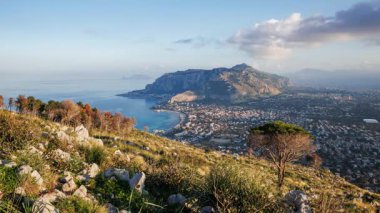 Günbatımını kaydeden zaman videosu Palermo şehrine tepeden bakan Riserva Naturale di Capo Gallo 'dan geceye dönüşüyor. Şehir ışıkları Monte Pellegrino ile birlikte şehir sahil şeridini yavaş yavaş aydınlatırken, sıcak akşam ışığı kayboluyor..