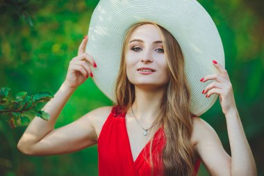 Kırmızı elbiseli ve şapkalı güzel bir kız.