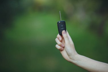 Kadın arabanın anahtarını tutuyor.